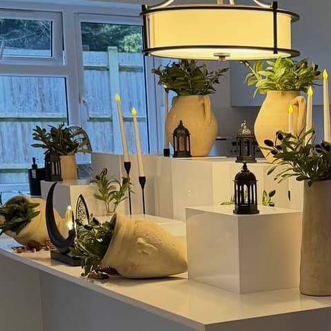 Styled plinths, lanterns, and vessels arranged as hire-ready decor pieces.